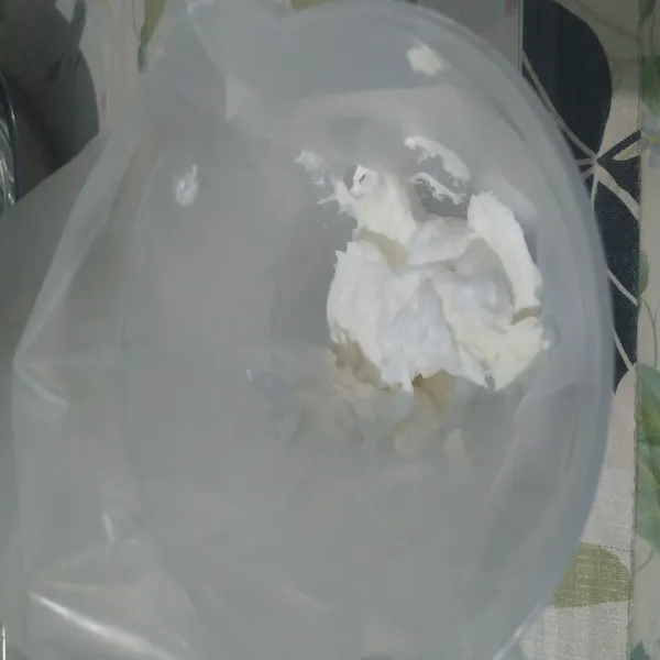 Siapkan wadah. Mixer whippy cream bubuk dan air dingin. Taruh hasilnya pada piping bag.
