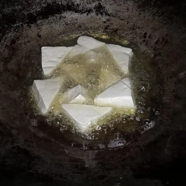 Potong tahu jadi dua dan goreng hingga berkulit.