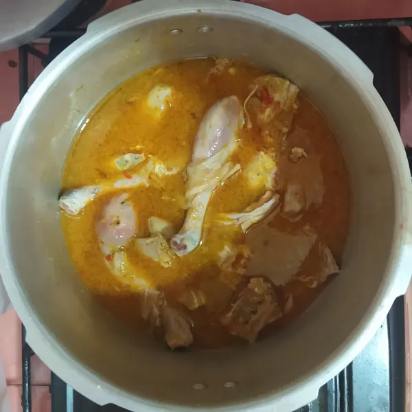 Masukkan ayam ke dalam panci presto, bumbu tumis dan air.