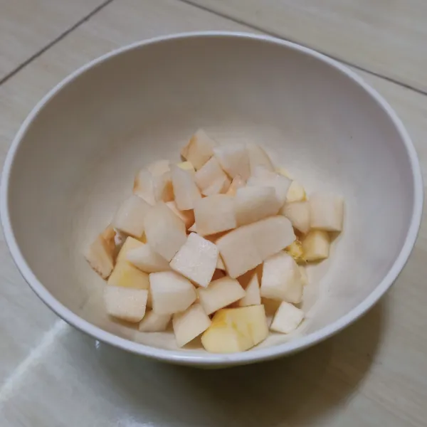 Potong dadu buah pear kemudian tambahkan ke mangkok sebelumnya