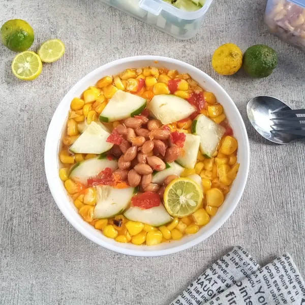 Siapkan mangkok. Masukkan jagung,mentimun dan kacang tanah. Kemudian siram dengan kuahnya. Beri perasan jeruk songkit. Sajikan.