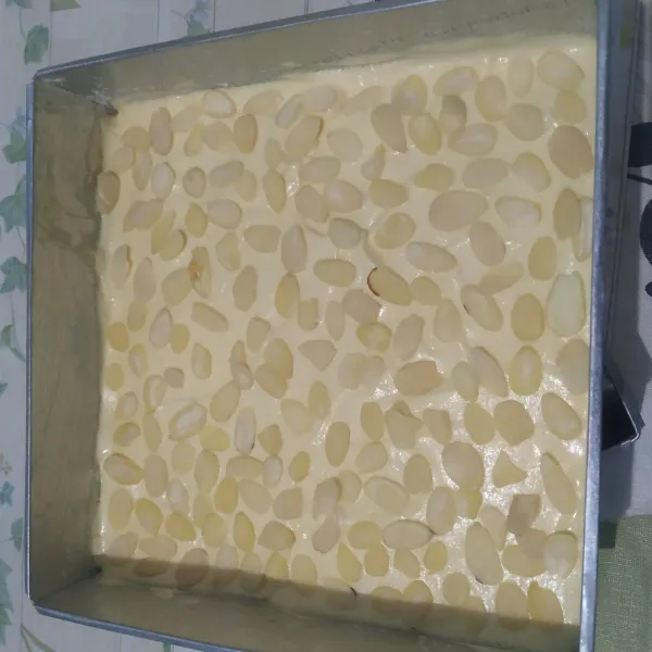 Siapkan loyang. Olesi dengan margarin dan taburi dengan sedikit tepung terigu. Masukan adonan kue. Ratakan. Beri toping kacang almond. Kukus 35 menit (sebelumnya kukusan sudah dipanaskan terlebih dahulu).
