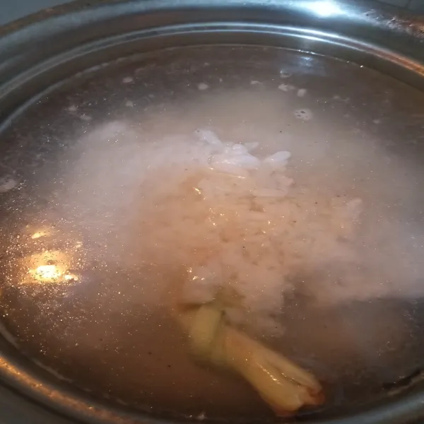 Masukkan nasi dingin hingga terendam. Aduk sesekali hingga nasi menjadi bubur. Dalam proses ini jika kurang air dan nasi masih berbentuk atau belum lembut, bisa ditambahkan air lagi.