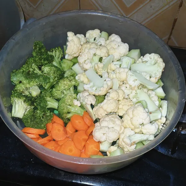 Potong brokoli dan wortel, cuci bersih lalu tiriskan.