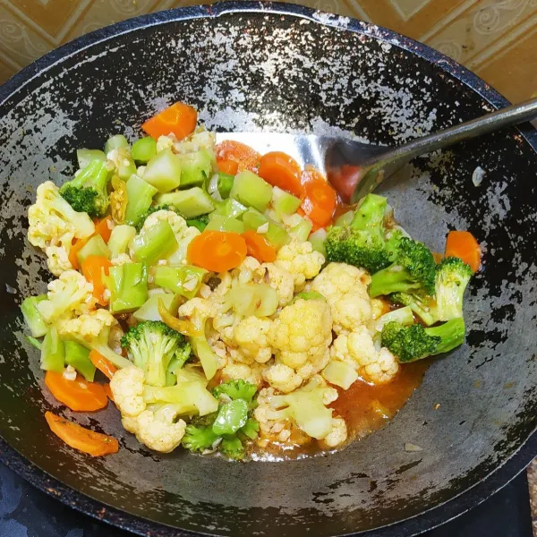 Tumis bawang bombai dan bawang putih sampai matang lalu masukkan brokoli dan wortel, tambahkan air.