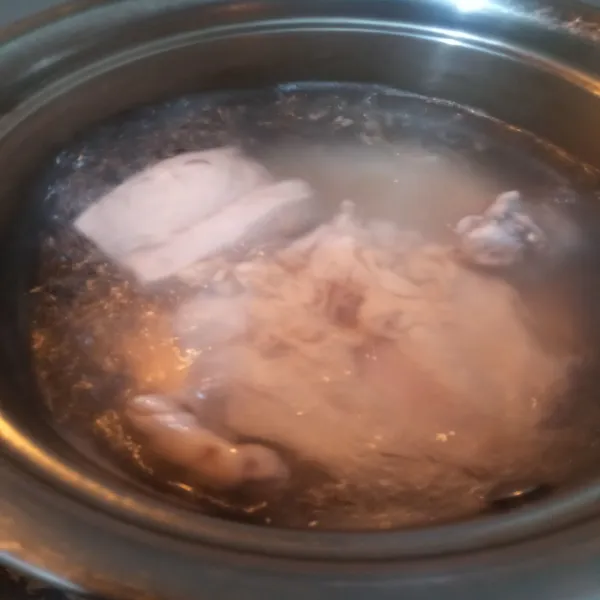 Cuci bersih ayam. Rebus dengan air sedikit kemudian buang airnya dan rebus kembali ayam hingga matang dengan api kecil supaya kaldu dari ayam keluar.