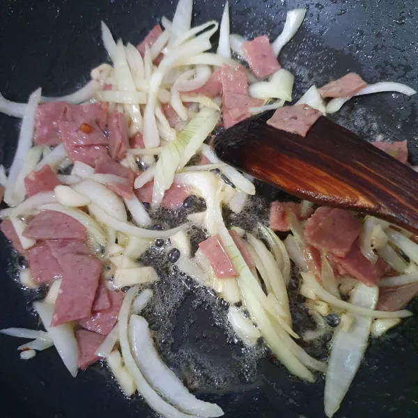 Panaskan minyak, masukkan potongan smoked beef, masak hingga mengering sebagian sisinya. Lalu masukkan bawang putih dan bawang bombay, masak hingga harum.