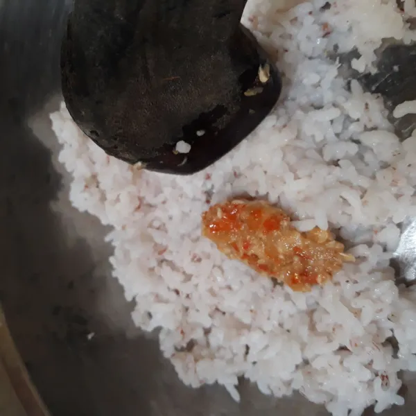 Campurkan bumbu halus ke dalam nasi sambil diuleg hingga tekstur nasi sedikit halus.