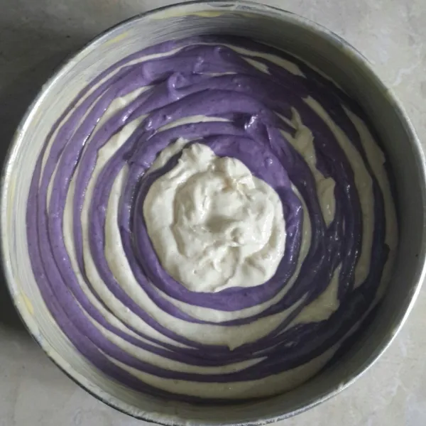 Tuang adonan ungu dan putih bergantian, lahkukan hingga semua adonan habis, hentak-hentakan tiga kali