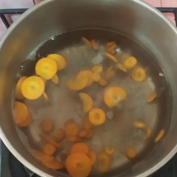 Didihkan air, masukkan wortel.