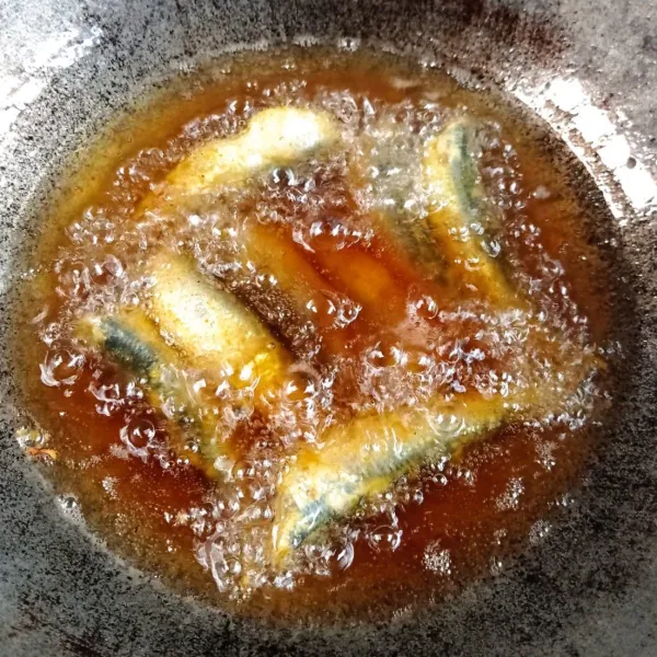 Panaskan minyak goreng, goreng ikan dengan api sedang sampai terlihat kering.