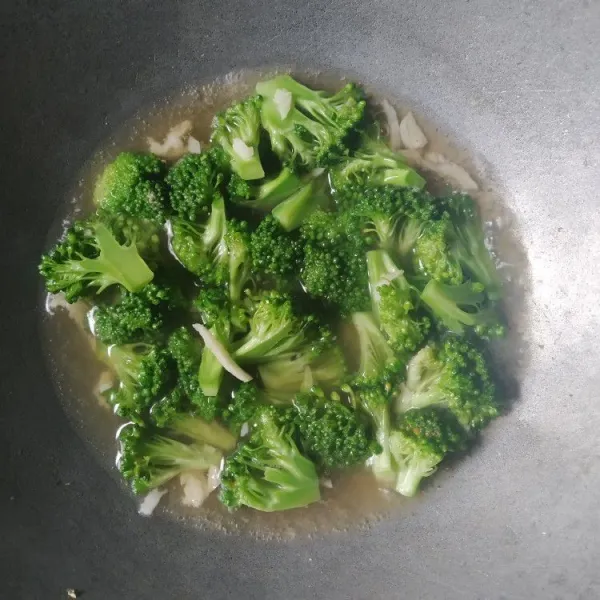 Tambahkan air, biarkan sedikit mendidih, bumbui dengan kaldu bubuk, kecap asin dan saus raja rasa, masak hingga brokoli empuk.