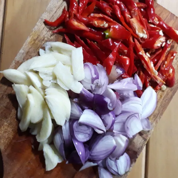 Cabe diiris sering agak tipis, bawang merah putih diiris tipis.