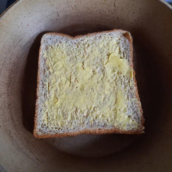 Membuat roti panggang : olesi semua sisi roti tawar dengan margarin. Panggang di teflon hingga garing.