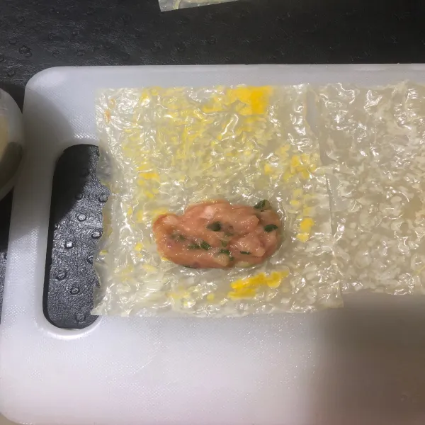 Letakkan adonan isi di kembang tahu. Letakkan dibagian tengah agak ke bawah, kemudian olesi tipis -tipis bagian yang tidak ada adonan isi dengan telur.