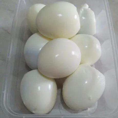 Rebus telur hingga matang lalu kupas kulitnya, tusuk-tusuk telur sedikit dengan garpu.