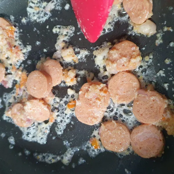 Tumis bumbu halus hingga harum. Masukkan sosis, aduk.