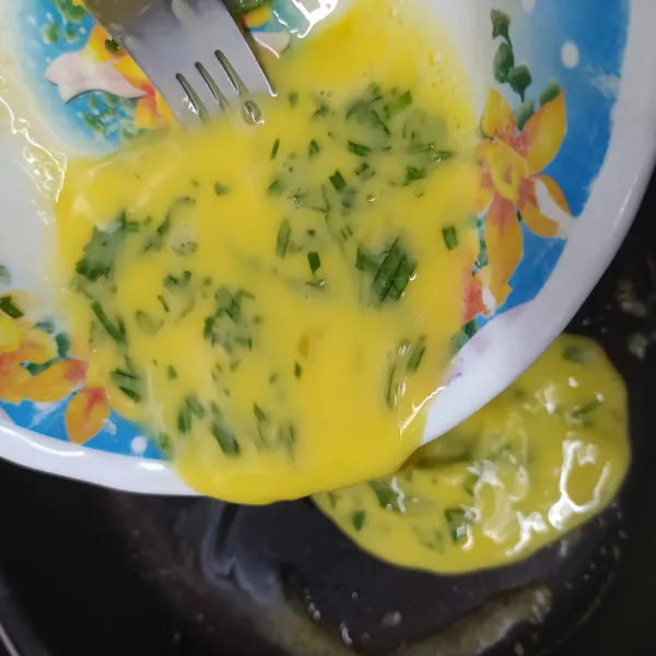 Tuang kocokan telur dalam wajan teflon.