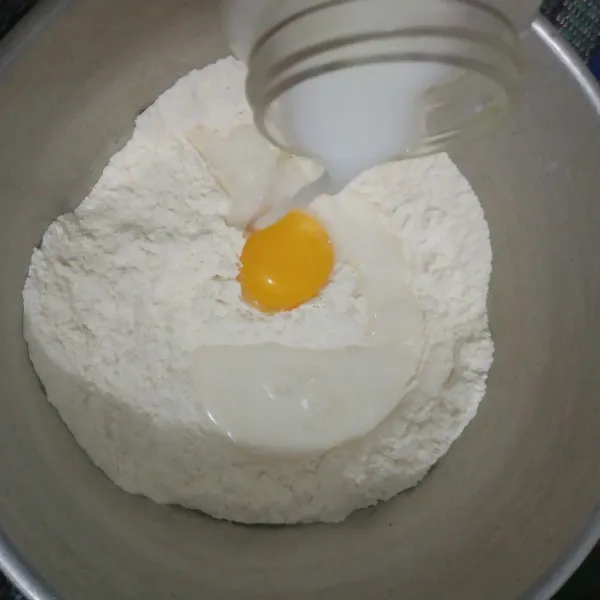Campur semua bahan kering, aduk rata lalu tambahkan kuning telur dan susu sedikit demi sedikit sambil diuleni setengah kalis. Susu jangan dituang semua, kalau dirasa sudah cukup hentikan saja supaya adonan tidak kelembekan.
