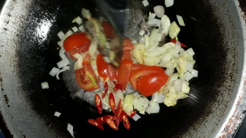 Setelah bawang harum dan layu masukan cabe dan tomat, tumis hingga layu.