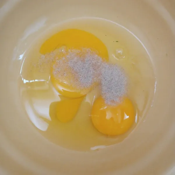 Pecahkan telur ke dalam mangkuk. Tambahkan merica.