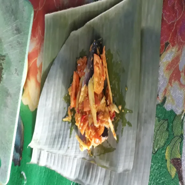 Bungkus ikan pada daun pisang dan semat dengan lidi.