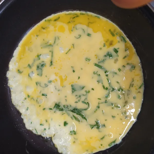 Tatakan kocokan telur sampai merata seluruh teflon.