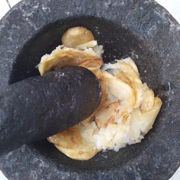 Tumbuk/haluskan kentang goreng panas-panas hingga halus