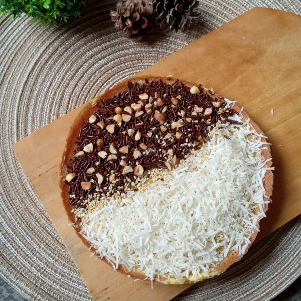 Angkat dari wajan lalu oles butter dipermukaannya. taburi topping sesuai selera. Kucuri kental manis. Potong-potong dan sajikan.