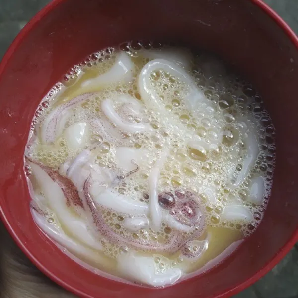 Kocok lepas telur, bumbui dengan sedikit merica dan garam. Marinasi cumi dengan kocokan telur.