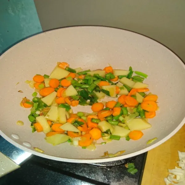 Masukan sayur-sayuran beserta daun bawang dan seledri, tambahkan gula garam dan lada bubuk. Masak sebentar hingga sayur layu saja