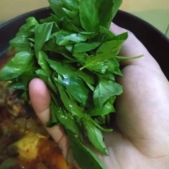 Masak sampai kuah menyusut dan bumbu meresap. Kemudian masukan kemangi, aduk sampai kemangi layu. Angkat dan sajikan.