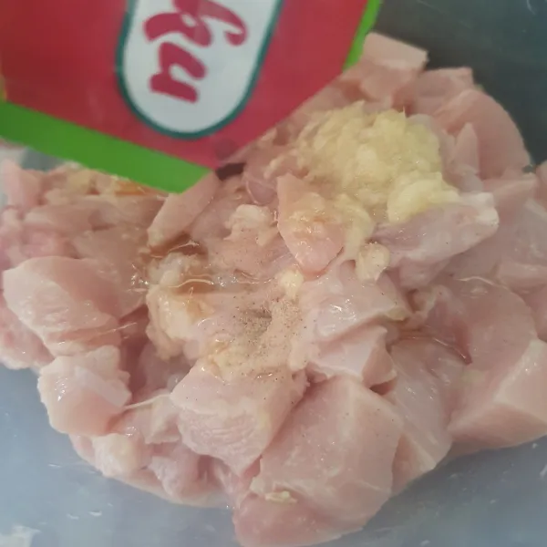 Haluskan bawang putih dan garam, masukkan ke dalam wadah ayam fillet. Tambahkan lada bubuk, minyak wijen, saus tiram. Marinasi ayam selama 30 menit.