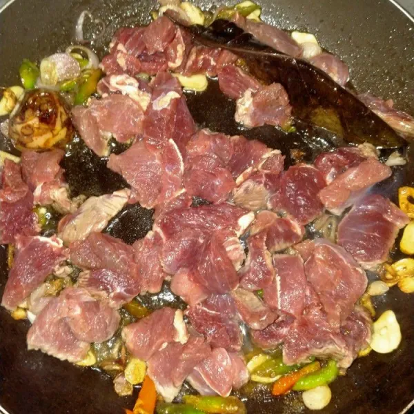 Masukkan irisan daging, aduk rata hingga keluar kaldu daging.