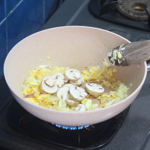 Tuang bombay dan bawang putih cincang di wajan yang sama, aduk sampai layu, kemudian masukan jamur, aduk rata sampai jamur layu.