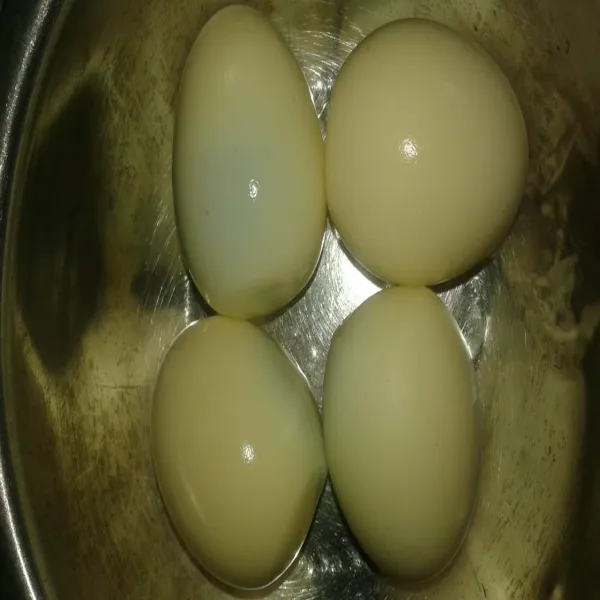 Rebus telur sampai cukup matang, angkat, kupas bersih kulitnya.