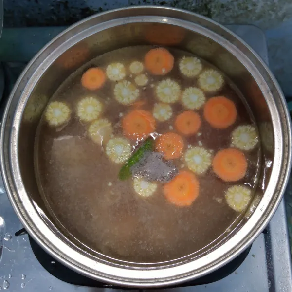 Masukan wortel, baby corn, air, gula, garam dan lada bubuk. Masak sampai wortel empuk.