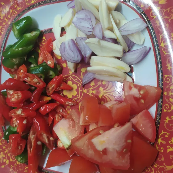 Siapkan bumbu, iris tipis bawang merah dan bawang putih. Iris serong cabe hijau, merah dan rawit. Potong tomat beberapa bagian.