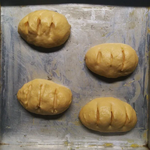 Bentuk sesuai selera. Letakkan di loyang, lalu kerat permukaanya menggunakan gunting/pisau yang tajam. Proofing selama 30-45 menit (mengembang 2 kali lipat).