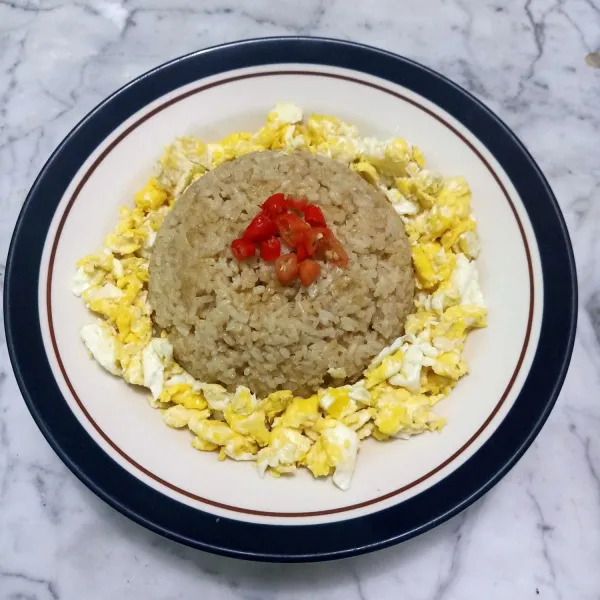 Lalu tata di piring nasi goreng matahari. Telur orak arik taruh dipinggiran nasi goreng. Lalu iris cengek /cabe rawit taruh di atas nasi.