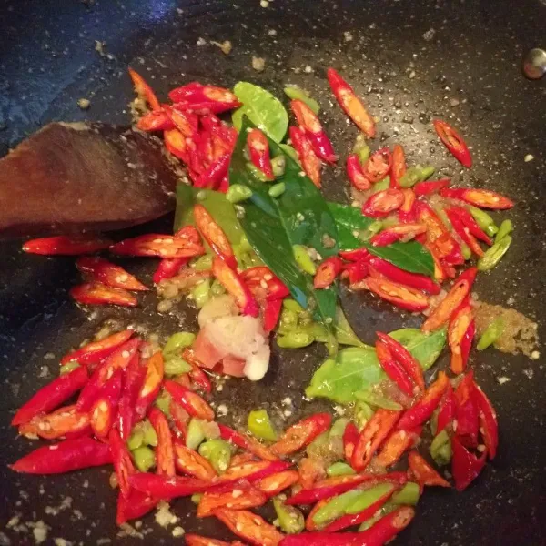 Lalu masukan daun jeruk daun salam lengkuas dan cabe, kecilkan api.