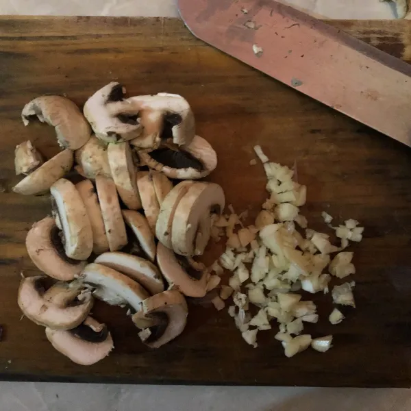 Cincang bawang putih lalu potong-potong jamur sesuai selera.