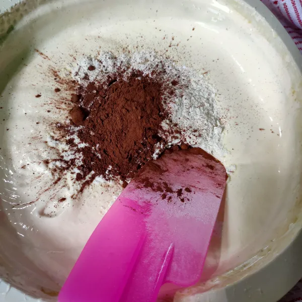 Kemudian tambahkan tepung terigu, vanili bubuk, coklat bubuk dan baking powder secara bertahap, aduk rata dengan spatula.