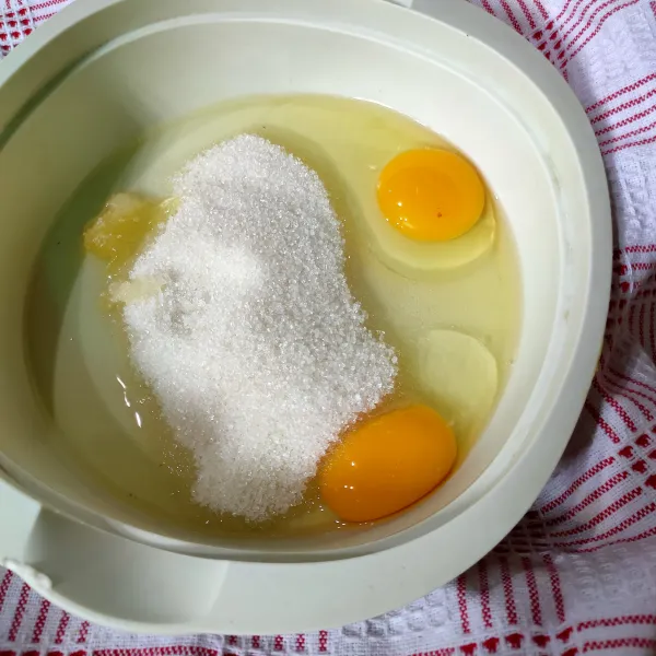 Langkah pertama, tuangkan dalam wadah, gula pasir, telur dan SP.