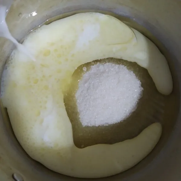Masukan gula pasir, minyak zaitun dan susu cair ke dalam panci lalu masak sampai gula larut sambil terus diaduk, lalu angkat dan dinginkan.
