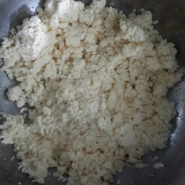 Kupas singkong, cuci bersih lalu parut. Peras dan buang airnya jangan terlalu kering.