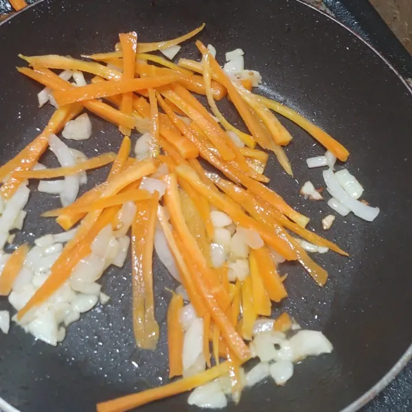 Panaskan 1 sdm minyak, lalu tumis bawang putih dan bawang bombay sampai harum. Masukkan irisan wortel dan masak sebentar.