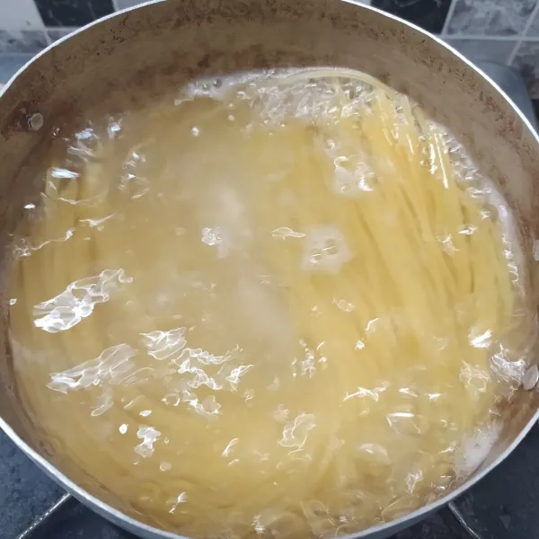 Rebus air, beri sedikit minyak goreng dan garam sampai mendidih. Masukkan spaghetti, rebus sampai aldente, tiriskan dan sisihkan.