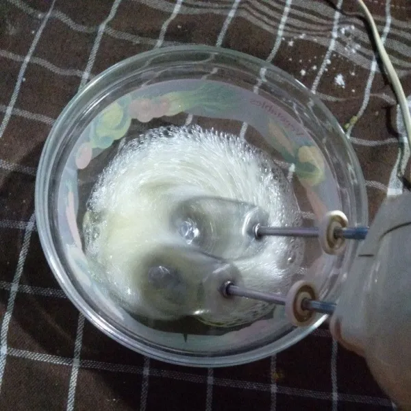 Mixer putih telur di wadah kaca yang bersih dengan kecepatan kecil memuji sedang secara perlahan selama kira-kira 5-6 menit