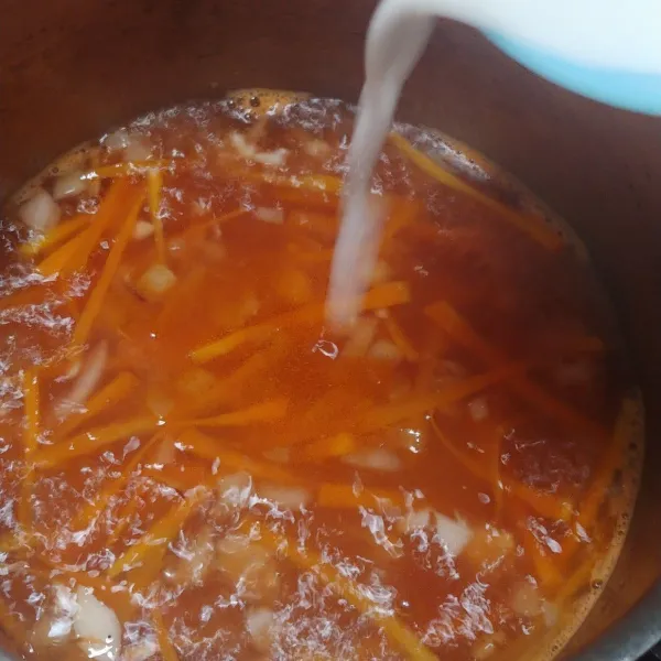 Lalu tuang tumisan wortel ke panci air mendidih. Masukkan saus tomat dan saus tiram, aduk rata. Lalu bumbui dengan gula dan garam. Kemudian, masukkan tepung maizena yang dilarutkan dengan air. Masak sampai saus mengental. Matikan api dan sajikan.